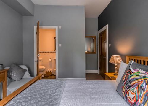 a bedroom with a king sized bed and a couch at Scotia House - Beautifully Presented Accommodation in Harrogate