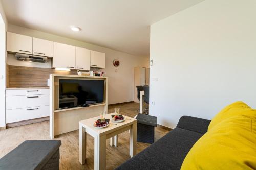 ein Wohnzimmer mit einem Sofa und einem Tisch in der Unterkunft Apartmaji BANONIA in Veržej