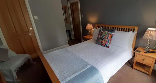 a bedroom with a large bed with two lamps and two tables at Scotia House - Beautifully Presented Accommodation in Harrogate