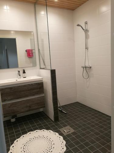 a bathroom with a sink and a shower at Majoitus Valkea in Nunnanen
