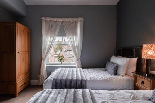 a bedroom with two beds and a window at Scotia House - Beautifully Presented Accommodation in Harrogate