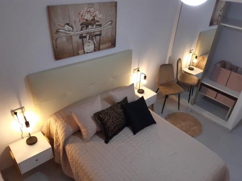 - une chambre avec un lit, deux lampes et un miroir dans l'établissement lovely apart 3 minutes to the beach, à Torrevieja