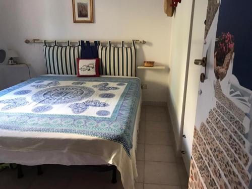 sypialnia z łóżkiem z niebiesko-białą kołdrą w obiekcie CASA IL TRAMONTO w mieście San Nicola Arcella