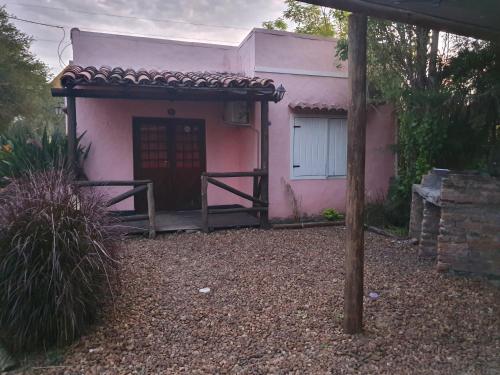 a pink house with a wooden door in front of it at Cabañas Peumayen in Colón