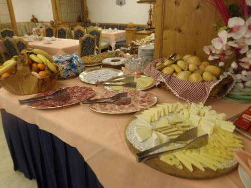 Una mesa con muchos platos de comida encima. en Hotel St. Raphael, en Madonna di Campiglio