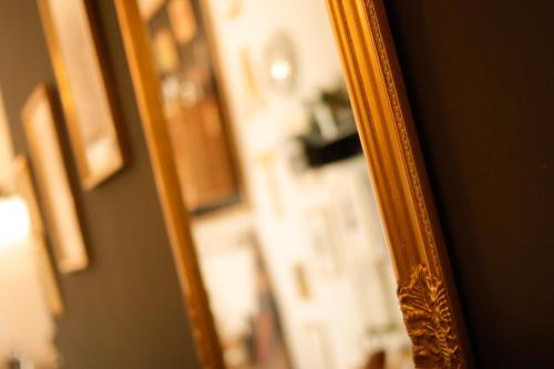 a mirror with a gold frame on a wall at Guest House Camilla in Alghero