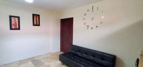 a room with a couch and a clock on the wall at NCG Suite in Guayaquil