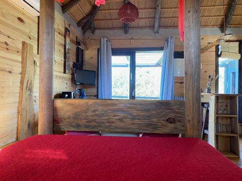 een slaapkamer met een rood bed en een raam bij Coral in Punta Del Diablo