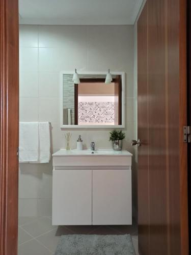 a white bathroom with a sink and a window at House Fifteen in Horta