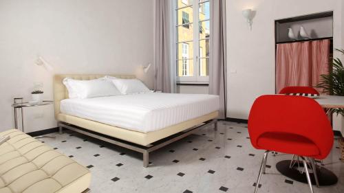 a bedroom with a bed and a red chair at Hotel Le Nuvole Residenza d'Epoca in Genoa