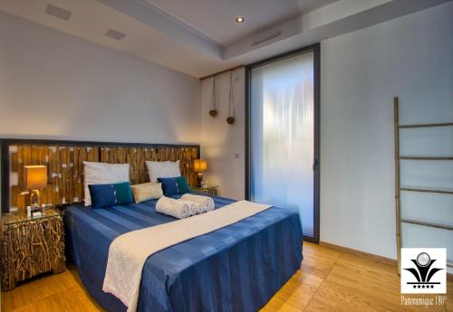 une chambre avec un grand lit avec des draps bleus dans l'établissement Panoramique 180 lac et montagne et Nid Secret spa romantique, à Annecy