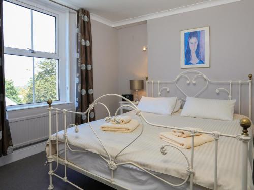 a bedroom with a white bed with towels on it at Wedgwood in Salcombe