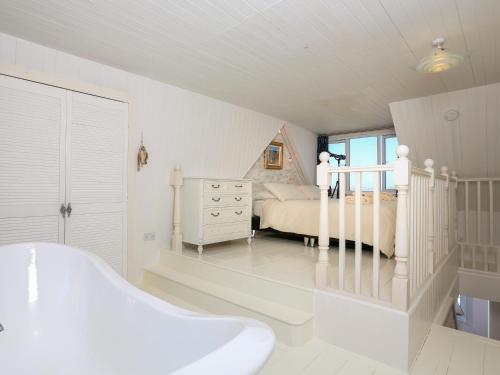 a white bathroom with a bed and a bath tub at Wedgwood in Salcombe