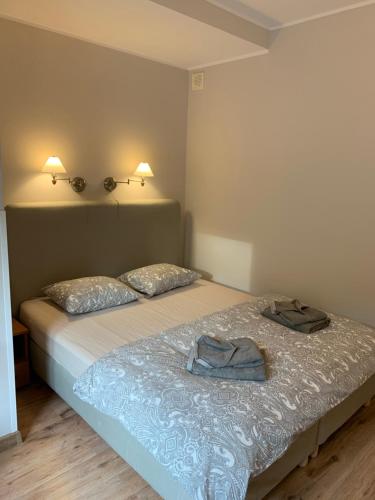 a bedroom with a bed with two towels on it at Ohana Budget w Juracie in Jurata