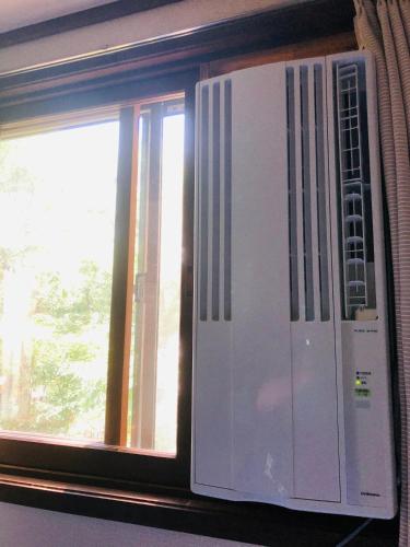 a window with a white appliance in front of it at The Guest House Japan Hakuba in Hakuba