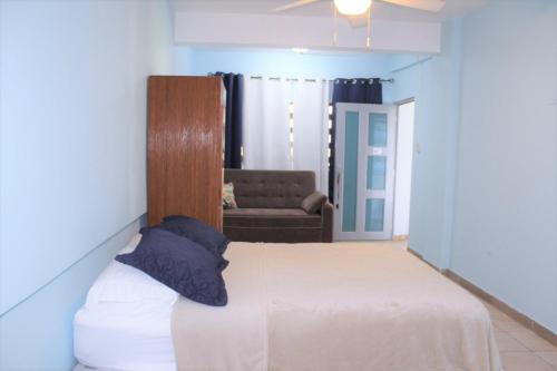 um quarto com uma cama e um sofá num quarto em Beachfront Studio in Aguada em Aguada