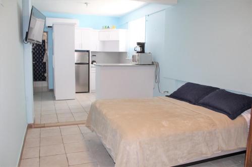 um pequeno quarto com uma cama e uma cozinha em Beachfront Studio in Aguada em Aguada