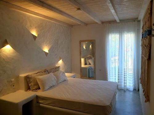 a bedroom with a white bed and a mirror at Simousea in Kithnos