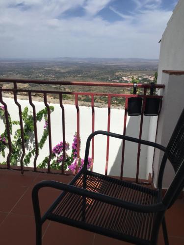 a bench sitting on a balcony with flowers at Casa do Sétimo Passo in Marvão