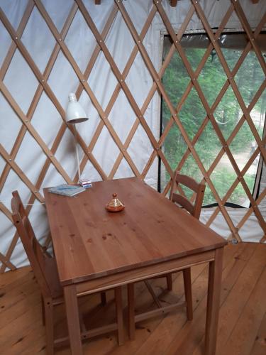 una mesa de madera y 2 sillas en una yurta en La Lumineuse des yourtes du petit ruisseau, en Mandeville