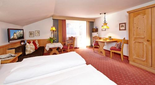 a hotel room with a bed and a living room at Hotel Franziska in Mittenwald