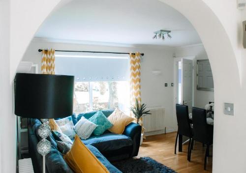 a living room with a blue couch and a table at Home to Home Stay Apartment in Hogganfield