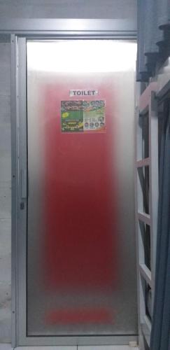 a red refrigerator with a sign on top of it at Home Addicts Hostel in Yogyakarta