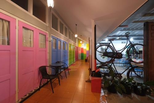 a hallway with colorful doors and chairs and bikes at Home Addicts Hostel in Yogyakarta