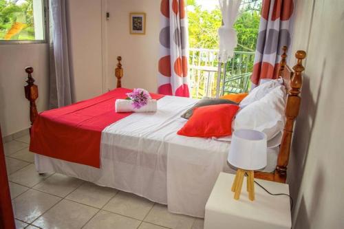 ein Schlafzimmer mit einem Bett mit Blumen darauf in der Unterkunft Le Domaine de Boisvin in Sainte-Anne