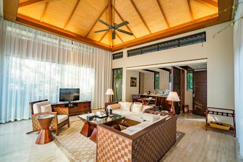 a living room with a couch and a tv at Grand Metropark Villa Resort Sanya Yalong Bay in Sanya