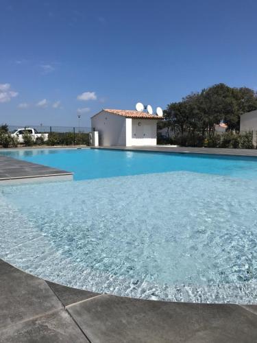 une piscine avec de l'eau bleue devant un immeuble dans l'établissement Mini villa K2, à Bonifacio