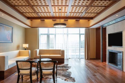 a living room with a table and chairs and a couch at Pullman Changbaishan Resort in Fusong