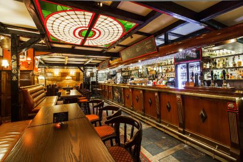 a restaurant with wooden tables and a bar at Elite Park Avenue Hotel in Gothenburg