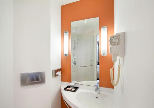 a bathroom with a sink and a mirror at Ibis Bandung Trans Studio in Bandung