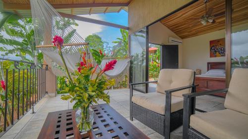 a porch with a vase of flowers on a table at La Finca Lodge in Fortuna