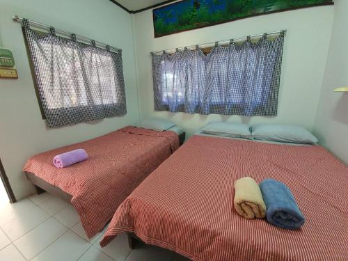 two beds in a bedroom with red comforter at pineapple resort in Ban Huai Thalaeng Phan