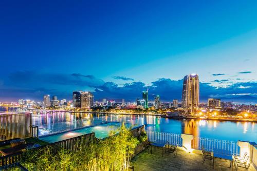 a view of a city skyline at night at IBIZA Danang Riverfront Hotel in Danang