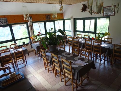 a dining room with tables and chairs and a large window at Auberge Le Bois du Cornet in La Forclaz