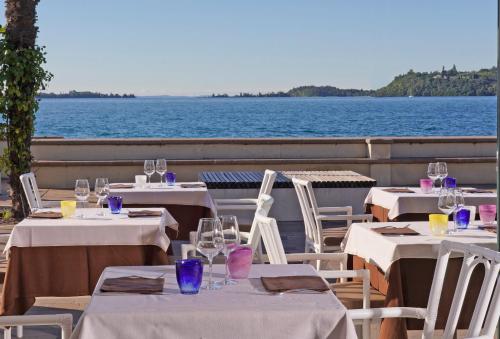 a group of tables with wine glasses on a boat at Hotel Du Lac Gardone Riviera in Gardone Riviera