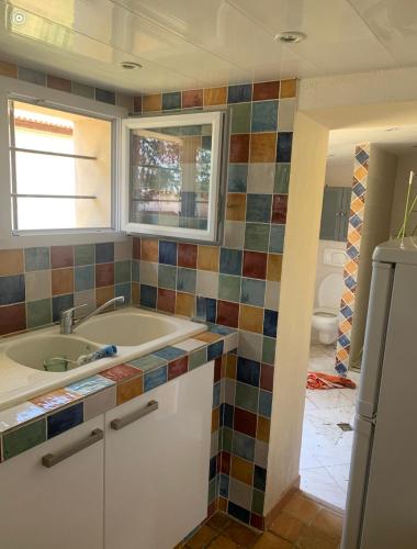 une salle de bain avec une baignoire, un lavabo et une fenêtre dans l'établissement Les Olivades, à Vauvert