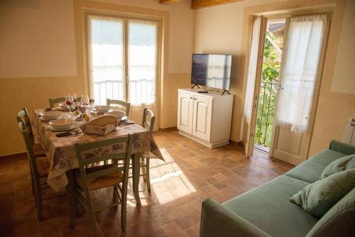 a dining room with a table and a couch at La Beppa - Casa Vacanza in Pontremoli