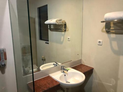 y baño con lavabo y espejo. en Kana Citra Guesthouse, en Surabaya