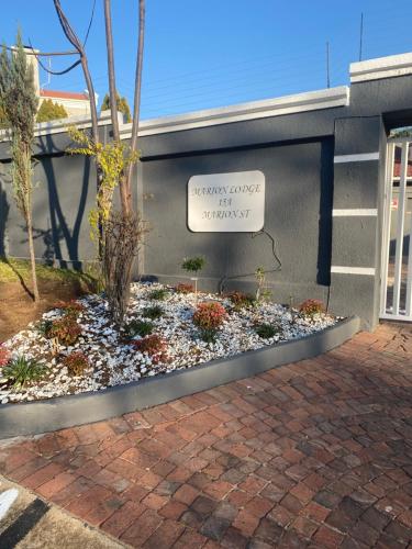 a sign on the side of a building with a flower garden at Marion Lodge in Johannesburg