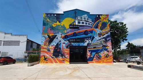 a building with a painting on the side of it at Chai Style Mansion in Ban Khlong Bang Bon