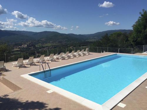 una piscina con sillas y vistas a las montañas en Belvilla by OYO Appartamento per 3, en Citerna