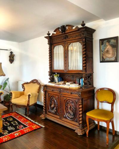 a large wooden cabinet in a room with two chairs at Conacul Paloși in Horezu