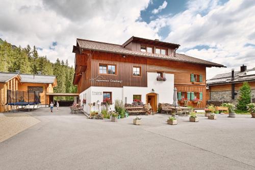 un gran edificio de madera con gente caminando delante de él en Appartement Omesberg 1, en Lech am Arlberg