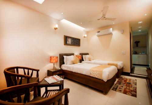 Schlafzimmer mit einem Bett, einem Tisch und Stühlen in der Unterkunft Imperial Apartments Huda City in Gurgaon