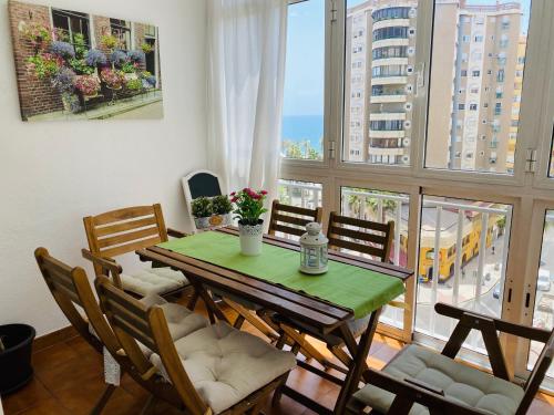 een eetkamer met een tafel en stoelen en een groot raam bij Malagueta Beach Premium in Málaga