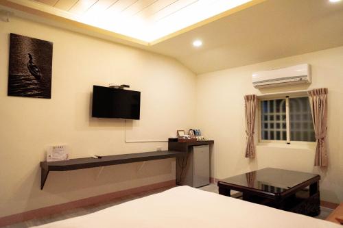 una camera da letto con TV a parete e tavolo di Forest a Manzhou